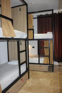萨兰达Central Boutique Hostel的一间房间,设有三张双层床