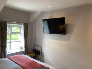 兰卡斯特The Stork Hotel的卧室配有一张床和壁挂式平面电视。