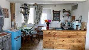 滨海索尔特本Wheelhouse - Grinkle Bell Cottage的一间带桌子的厨房和一间带蓝色家电的厨房