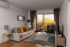 马普托Xenon Urban Apartments的带沙发和大窗户的客厅