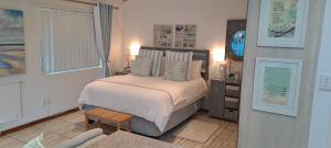 布隆方丹Gabbys Cottage Guesthouse的一间卧室配有一张床、一张桌子和一个窗户。