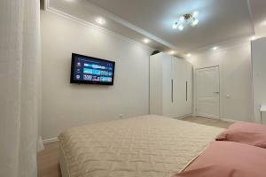 塔尔迪科尔Nova Center - SQ的卧室配有一张床,墙上配有电视。