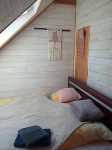 Ozierański Eden "Pod rzeźbami"的卧室配有木墙内的一张床