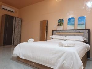 图鲁斯杜Tropical stay Thulusdhoo的卧室配有一张带白色床单和枕头的大床。