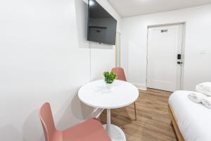 加尔维斯敦Pastel Tropics Studio Apartment的白色的客房配有桌椅和一张床