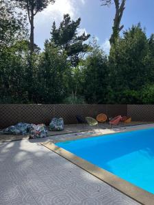 圣让-德吕兹Résidence Chateau d'Acotz - Appartements avec piscine à 600m des plages à Saint-Jean-de-Luz的围栏旁带椅子的游泳池