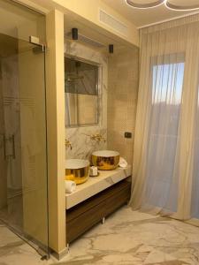 里乔内Ale Suite Sea Side View - Hotel Arizona的一间带两个水槽和玻璃淋浴间的浴室