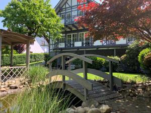 奥尔珀Apartment DaVinci - Sauna, Kamin, Garten, E-Bikes的一座桥,在一座房子前面的池塘上