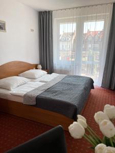 梅尔诺薇拉米兰民宿的一间卧室设有一张床和一个大窗户