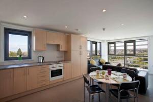 爱丁堡Edinburgh College Residence的厨房以及带桌子和沙发的客厅。