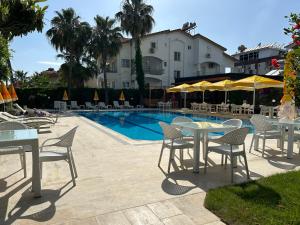 锡德Bellissima Hotel的一组桌子和椅子,位于游泳池旁