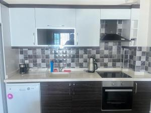 EtimesutEryaman, Wide Luxury Rezidance的厨房配有白色橱柜和水槽