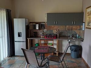 马加利斯堡Votadini Country Cottages的厨房配有桌椅和冰箱。