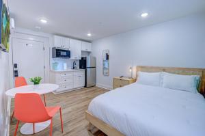 加尔维斯敦Caribbean Sea Studio Apartment的卧室配有一张床和一张桌子及椅子