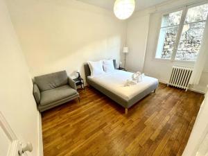 巴黎Lovely appartment - Buttes Chaumont-ParisZenith的一间卧室配有一张床、一张沙发和一把椅子