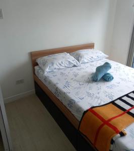 马尼拉SM Bicutan Rooms的一张床上有一只蓝色的填充动物