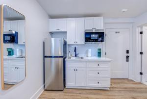 加尔维斯敦Roaring Tigers Studio Apartment的厨房配有白色橱柜和不锈钢冰箱