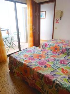 丰卡连特德拉帕尔马Pensión Los Volcanes的一间卧室配有两张床和鲜花毯子。