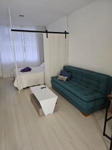 布宜诺斯艾利斯LaMari的客厅配有绿色沙发和床。