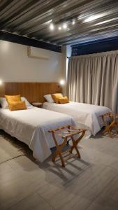 门多萨718 Rufino Petit Hotel的客房设有两张床和窗户。