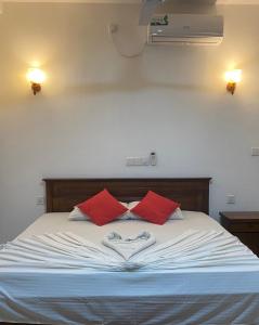 阿鲁特伽马Nesh Villa的一张带红色枕头的床,心