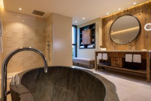 韦基奥圣露西港口Les Regalia Hôtel & Spa的一间带大浴缸和镜子的浴室
