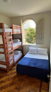 贝洛奥里藏特Nuh Hostel - Lourdes的一间卧室设有两张双层床和一扇窗户。