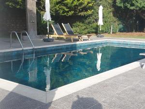 德鲁西亚Villa Angela的游泳池旁设有两把椅子和一张野餐桌