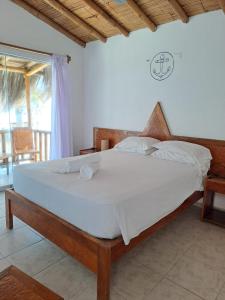 曼克拉Hotel Casa Mediterranea Mancora的一间卧室配有一张带白色床单的大床