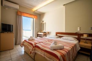 罗达奇诺Polyrizos Hotel的一间卧室配有一张大床和毛巾