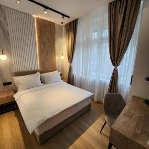 贝尔格莱德城市栖息地现代舒适套房旅馆的卧室配有白色的床和椅子