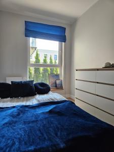 格丁尼亚Nadmorski apartament premium的一间卧室设有蓝色的床和窗户。