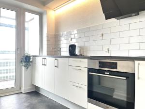 科灵Newly Renovated Apartment With 1 Bedroom In Kolding的厨房配有白色橱柜和烤箱。