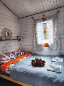 下乌斯奇基Bojkolandia的一间卧室配有鲜花床和窗户