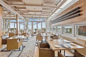 纳沙泰尔帕拉菲特酒店的餐厅设有桌椅和窗户。