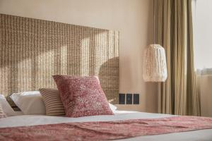 图卢姆Copal Tulum Hotel的一间卧室配有一张带粉红色枕头的床