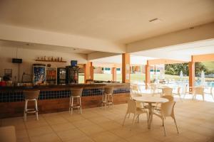 卡皮托利乌Engenho da Serra Hotel EcoResort的一间带桌椅的餐厅和一间酒吧