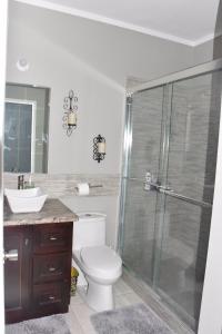 Spanish TownCozy and Secure Jacaranda Home的带淋浴、卫生间和盥洗盆的浴室