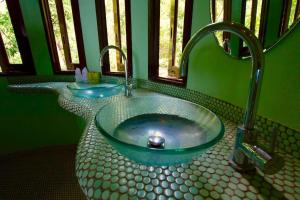 涛岛猴花别墅酒店的浴室设有玻璃碗水槽和水龙头