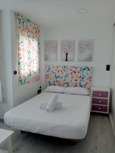 多列毛利诺斯TORREMOLINOS CENTER ESTUDIO Sun & Beach的卧室配有白色的床,墙上挂有两幅画作
