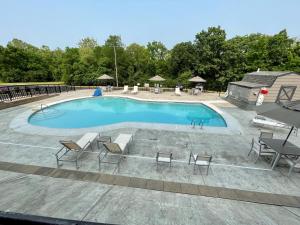 厄兰格Country Inn & Suites by Radisson, Erlanger, KY的大型游泳池配有桌椅