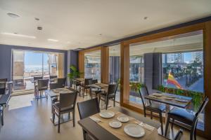 加的斯加的斯广场Spa酒店的餐厅设有桌椅和大窗户。