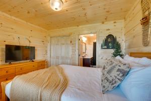 加特林堡Gorgeous Gatlinburg Cabin Large Deck and Hot Tub!的小屋内一间卧室配有一张床和电视
