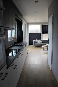 TwistFerienhaus Aurora, Sauna, Seeblick, angeln的一间带白色橱柜的厨房和一间客厅