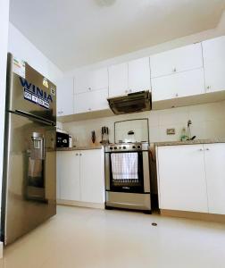 皮乌拉Dpto 3 hab en Piura - GARDEN 360~的厨房配有白色橱柜和不锈钢烤箱