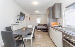 波尔杰Cozy Apartment In Dobrinj, Otok Krk With Kitchen的厨房以及带桌子和沙发的用餐室。