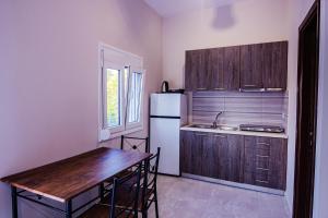 拉里萨Harmony Apartments的厨房配有桌子和白色冰箱。