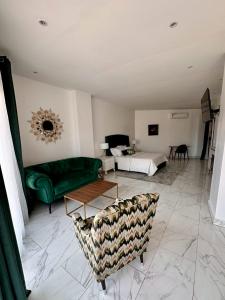 达喀尔Residence INFINITE的客厅配有绿色沙发和床。