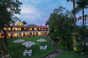 库埃纳瓦卡Anticavilla Hotel Restaurante & Spa的庭院中带雨伞的建筑的空中景观
