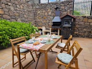 贝加德圣马特奥Villa MOGAREN的庭院设有木桌、椅子和壁炉